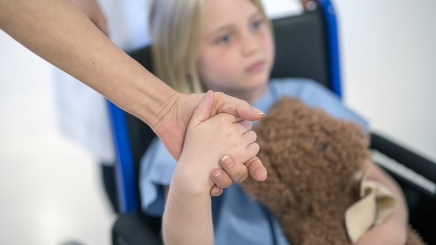 Jeune fille paralysée qui tient un toutou.
