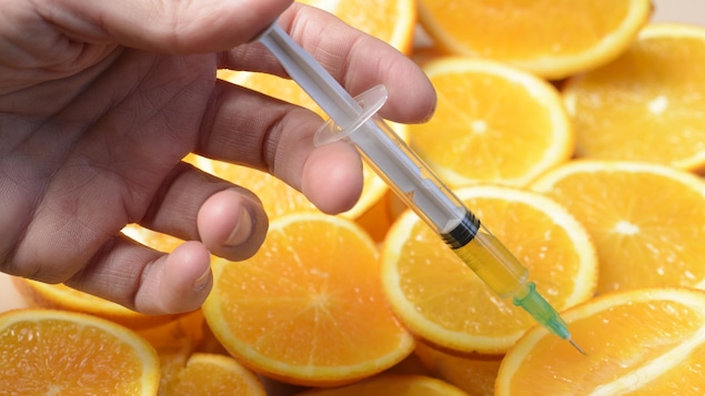 Une seringue dans des oranges, pour symboliser la vitamine C et les injections.