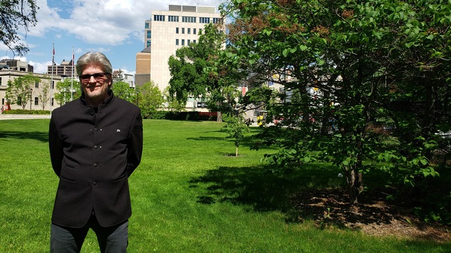 Laurent Lacroix, passionné de la musique et du plein air. Il est debout dans un jardin près d'un arbre.