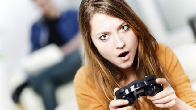 Jeune femme tenant une manette de jeu.