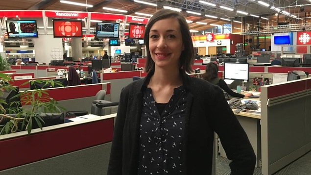 Une femme est photographiée debout dans une salle de nouvelles.