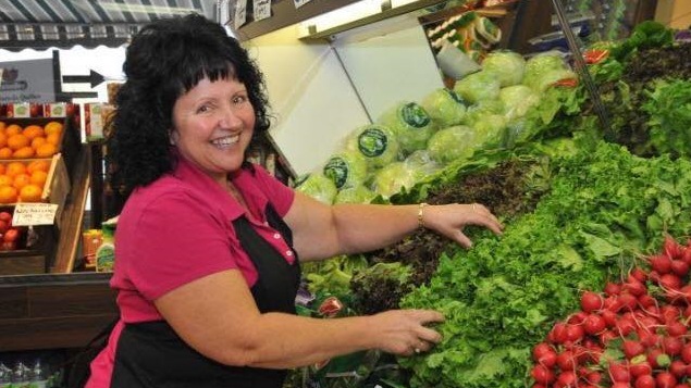 La maraîchaire devant un étalage de légumes