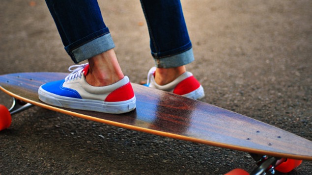 Des pieds sur une plache à roulettes longue