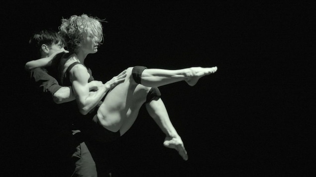 Louise Lecavalier, les jambes levées et pointées, est soulevée dans les airs par son partenaire de danse.