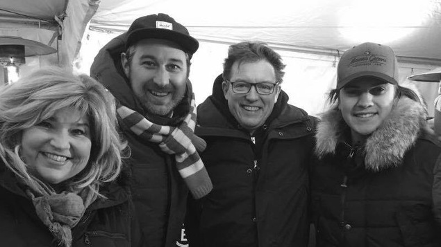 Portrait en noir et blanc d'une femme et de trois hommes souriants.