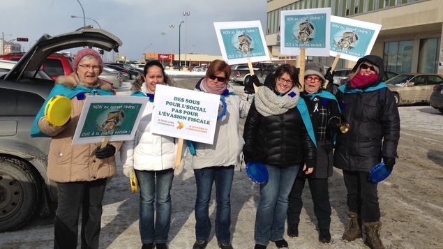 Action des centres de femmes à Sept-Îles concernant les politiques d’austérité et le corset libéral : des femmes manifestent avec des pancartes
