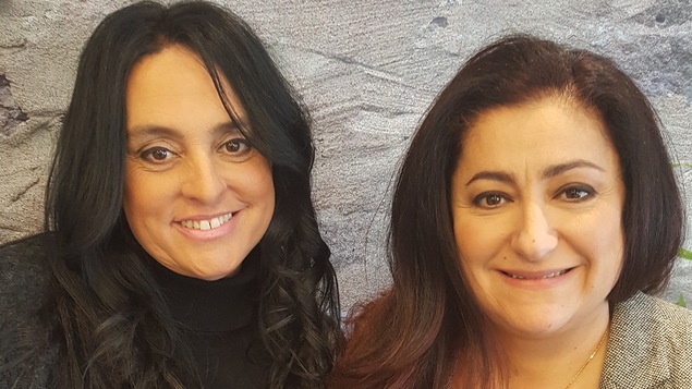 Les deux femmes posent pour la caméra avec un livre à la main