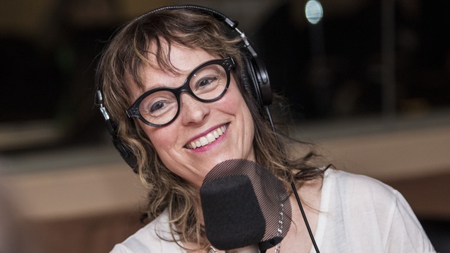 Elle sourit à la caméra.