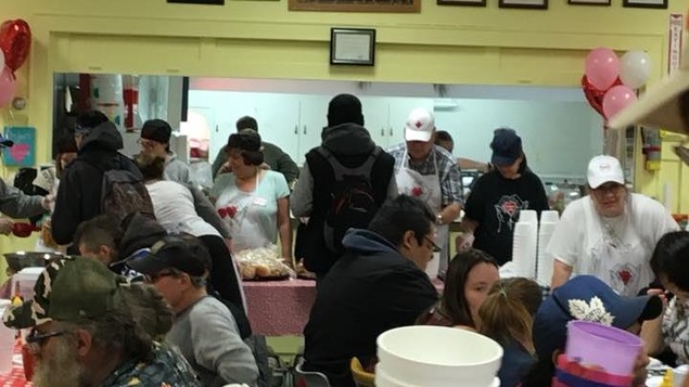Un repas est servi dans une salle communautaire