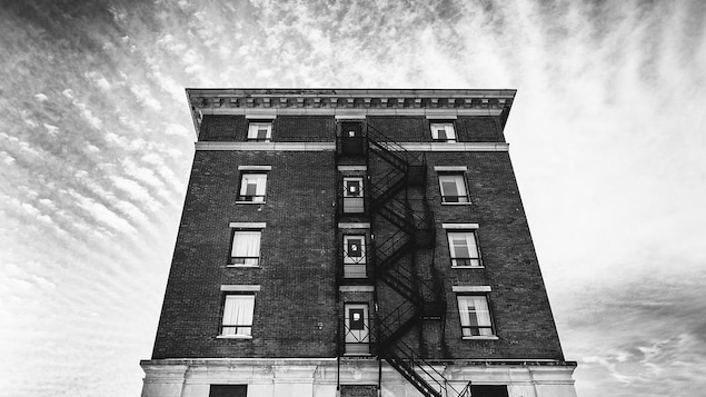 Un édifice de briques avec un escalier d'urgence au centre de l'édifice.