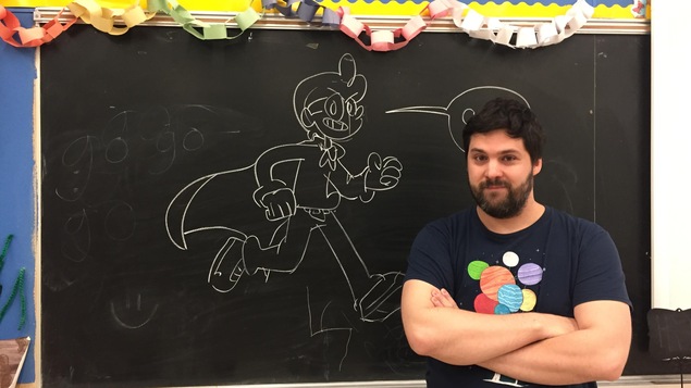 Yves Bourgelas devant le tableau en salle de classe. Un croquis y a été dessiné à la craie.