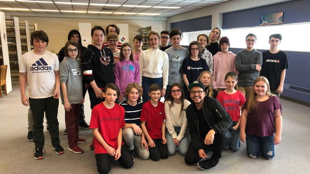 Le comédien et humoriste Mehdi Bousaidan en compagnie d'étudiants de la polyvalente des Baies de Baie-Comeau