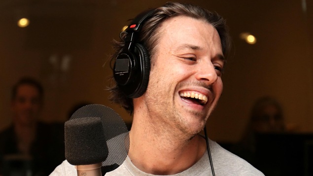 Mickaël Gouin riant dans un studio de radio.