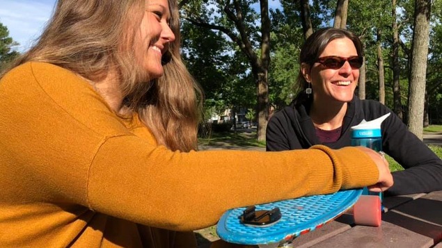En été, deux femmes souriantes dans un parc