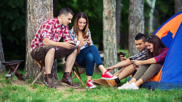 Des adeptes du camping utilisent des applications mobiles.