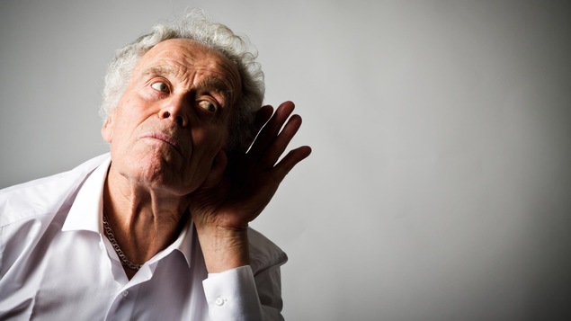 Un homme âgé met une main contre son oreille peut mieux entendre.