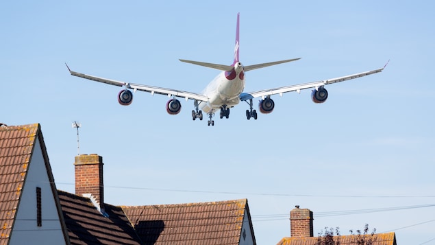 Un avion passe au-dessus d'un quartier.