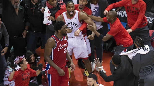 Un joueur de basketball manifeste sa joie avec des spectateurs.
