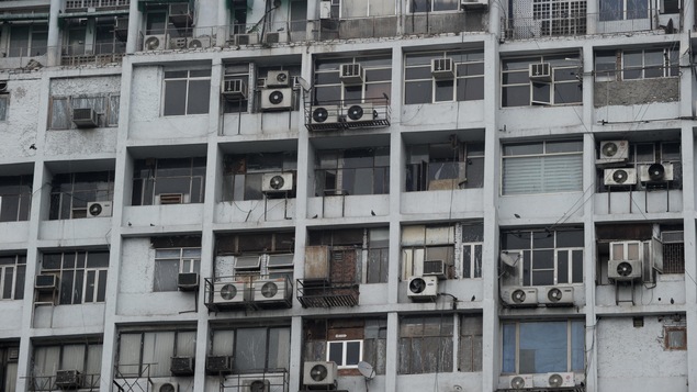 Vue sur un mur de bloc d'appartements muni de nombreux climatiseurs à New Delhi, en Inde.