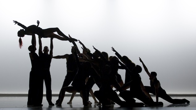 Silhouettes de danseurs effectuant une chorégraphie sur fond blanc.