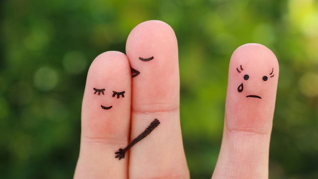 Deux doigts collés symbolisent un couple uni, à côté d'un doigt aux yeux tristes symbolisant la tristesse.