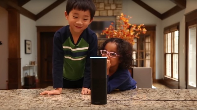 Deux enfants s'amusent avec un haut-parleur intelligent d'Amazon.