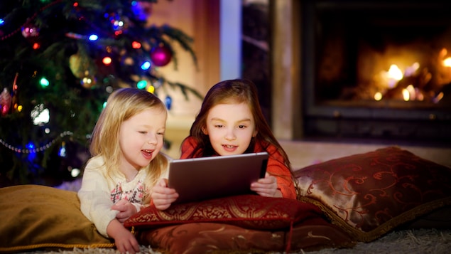 Deux soeurs regardent la télévision sur une tablette.