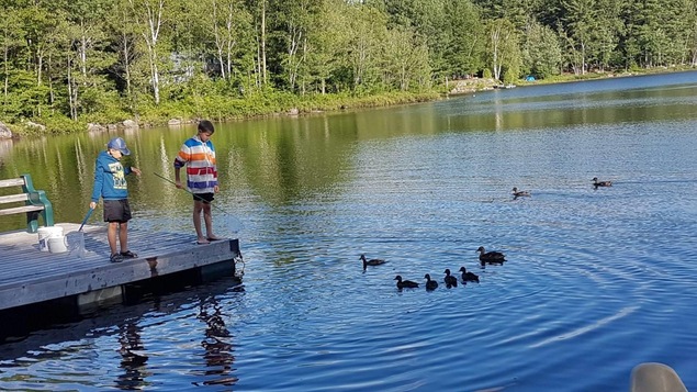 Deux petits garçons s'amusent sur un quai.