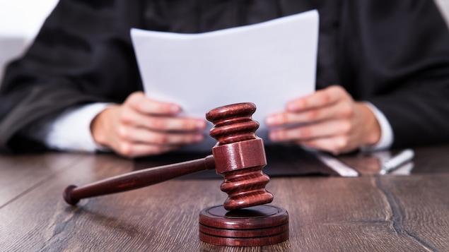 Un juge tient un document derrière son maillet