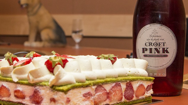 Un fraisier à côté d'une bouteille de porto rosé Pink Croft.