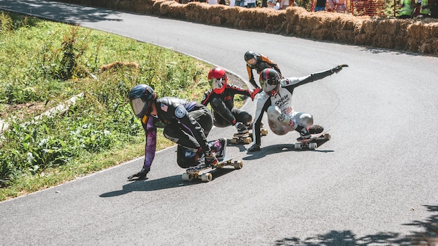 Quatre concurrents dévalent une pente à toute vitesse à la Coupe du monde de planche longue, en République tchèque.