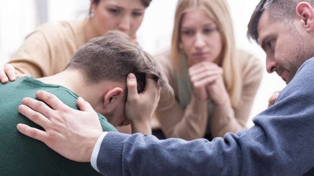 Un homme est consolé dans une thérapie de groupe.