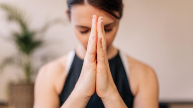 Une femme pratique la méditation.