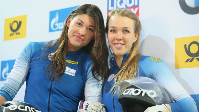 Les bobeuses Nadezhda Segeeva et Anastasia Kocherzhova tiennent leur casque en regardant la caméra.