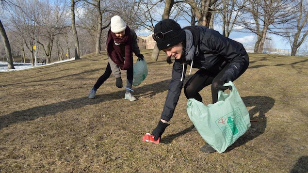 Des gens s'affairent à ramasser des déchets dans un parc.