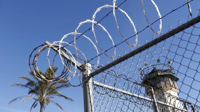 Une clôture surmontée de fil barbelé autour d'une prison, en Californie.