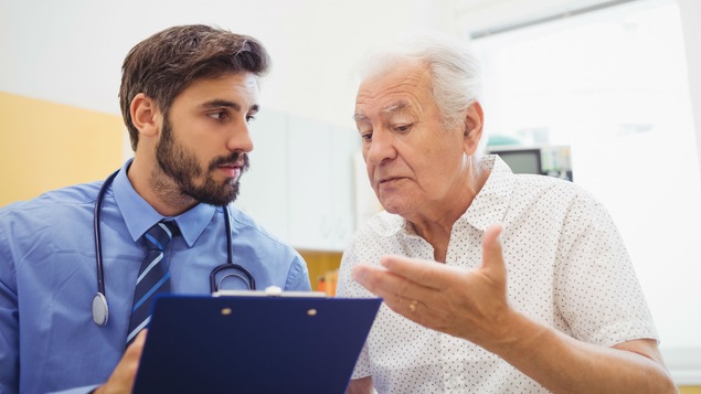 Un homme âgé discute avec son jeune médecin.