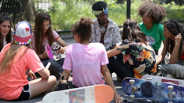 De jeunes planchistes sont assises dans un parc, à New York.