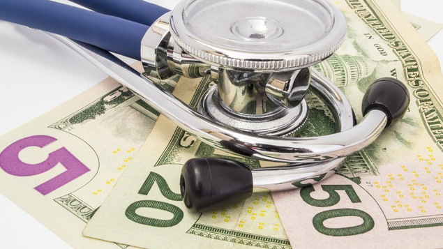 Un stéthoscope sur des billets de banque.