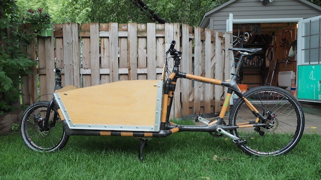 Un vélo allongé dont la partie antérieure au guidon est occupée par un réceptacle.