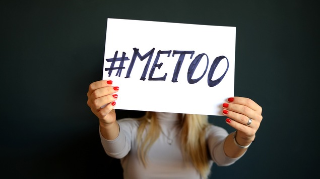Une femme tenant une affiche où il ai écrit #metoo.