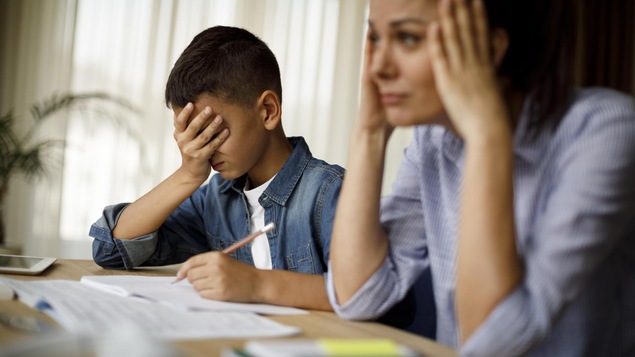 Une mère est impatiente avec son enfant qui fait ses devoirs.