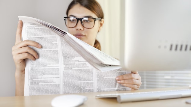 Une femme lit un journal.