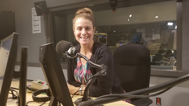 Une femme, Nathalie Nadon, devant un micro dans un studio de Radio-Canada.