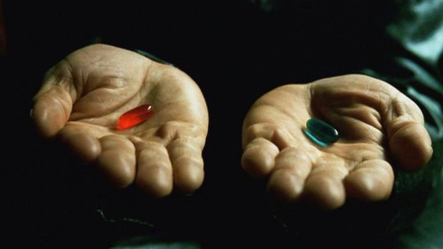 Deux mains tendues, celle de gauche avec une pilule rouge et celle de droite avec une pilule bleue.