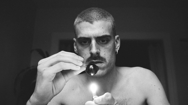 Autoportrait en noir et blanc de Yannick Fornacciari avec un briquet et une pipe.