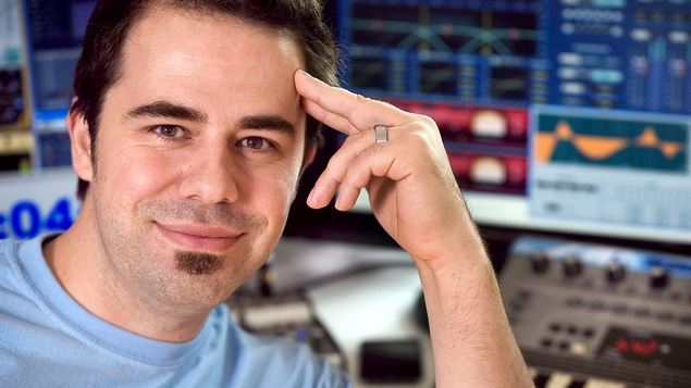 L'invité pose devant une console d'enregistrement sonore.