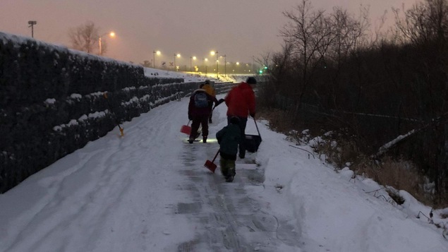 Des adultes et enfants avec pelles à la main