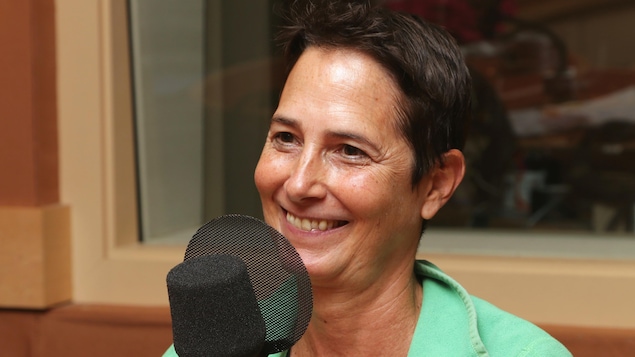 Photo d'Hélène Cyr devant un micro de radio.