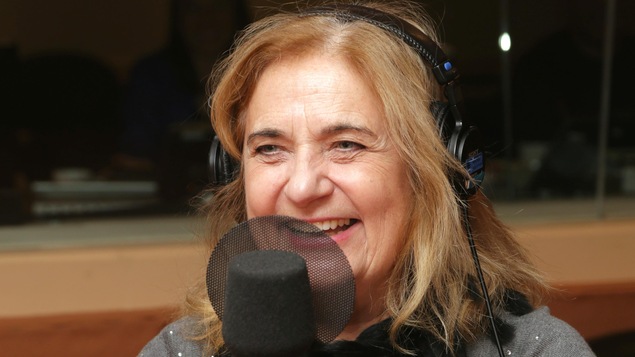 Photo de Nathalie Petrowski devant un micro de radio.